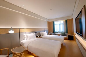 A hotel room with two beds, a desk, a chair, a TV, and a window with curtains. - Ji Hotel Guangzhou Baiyun Airport Terminal 2 (Guangzhou)