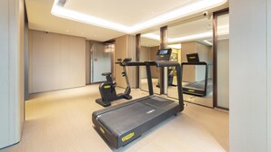 A modern hotel room with a treadmill, exercise bike, and a large mirror reflecting the room. - Ji Hotel Guangzhou Baiyun Airport Terminal 2 (Guangzhou)