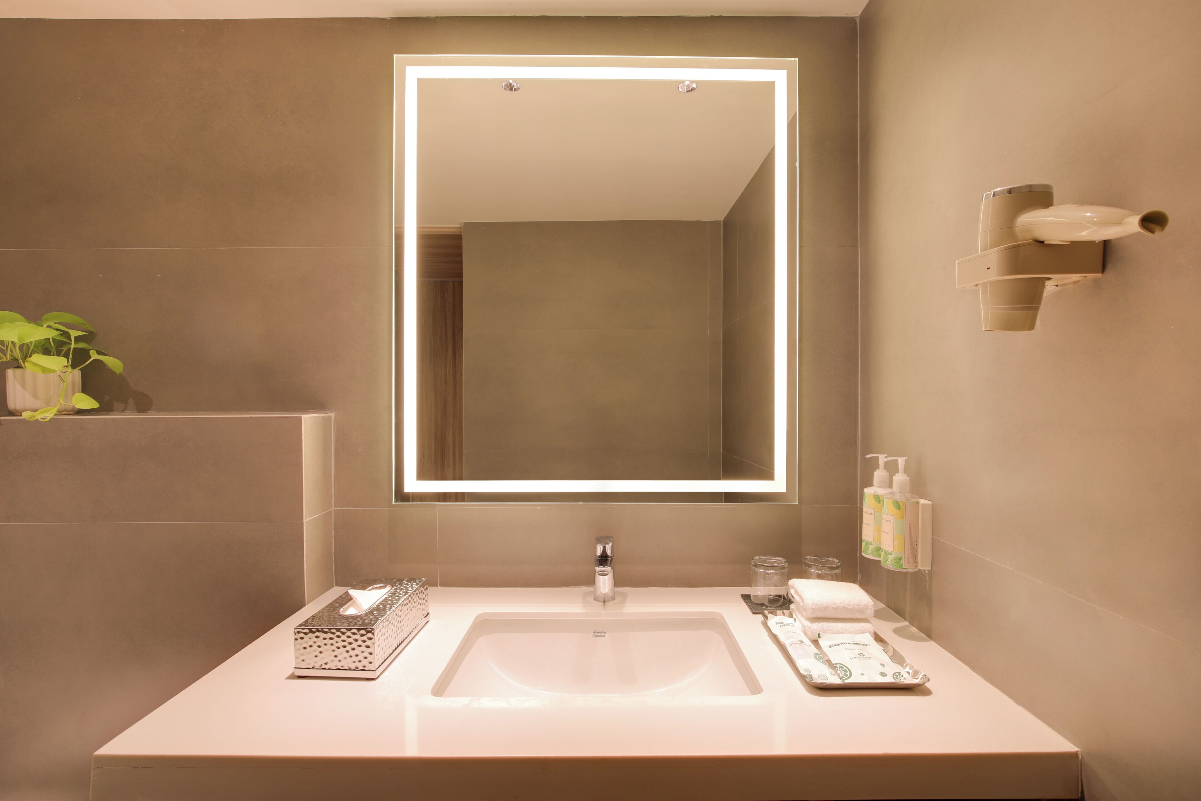 Un baño moderno con un espejo grande, un lavabo y un perchero para toallas.