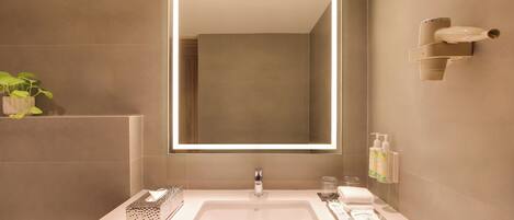 Un baño moderno con un espejo grande, un lavabo y un perchero para toallas.