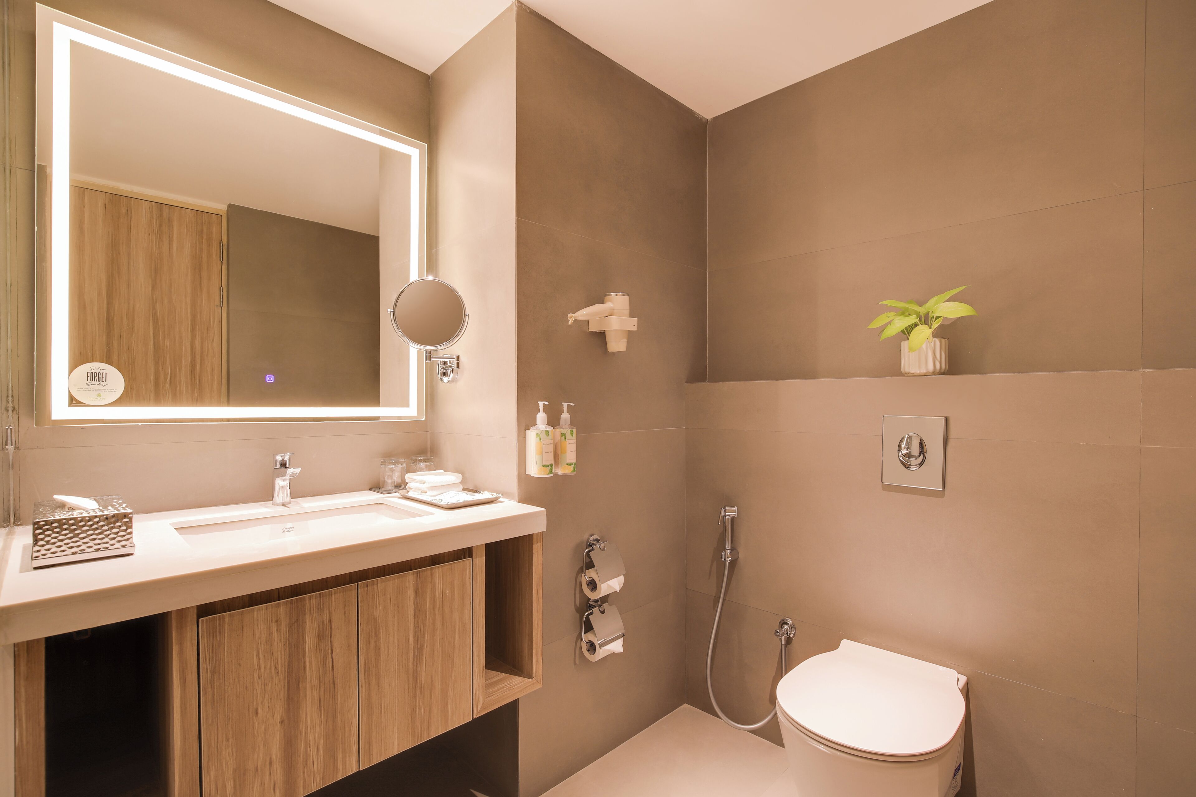 A modern bathroom with a wooden vanity, a large mirror, a shower, and a toilet.