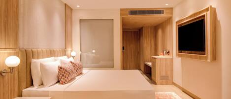 A modern hotel room with a large bed, bedside table, and a TV mounted on the wall.
