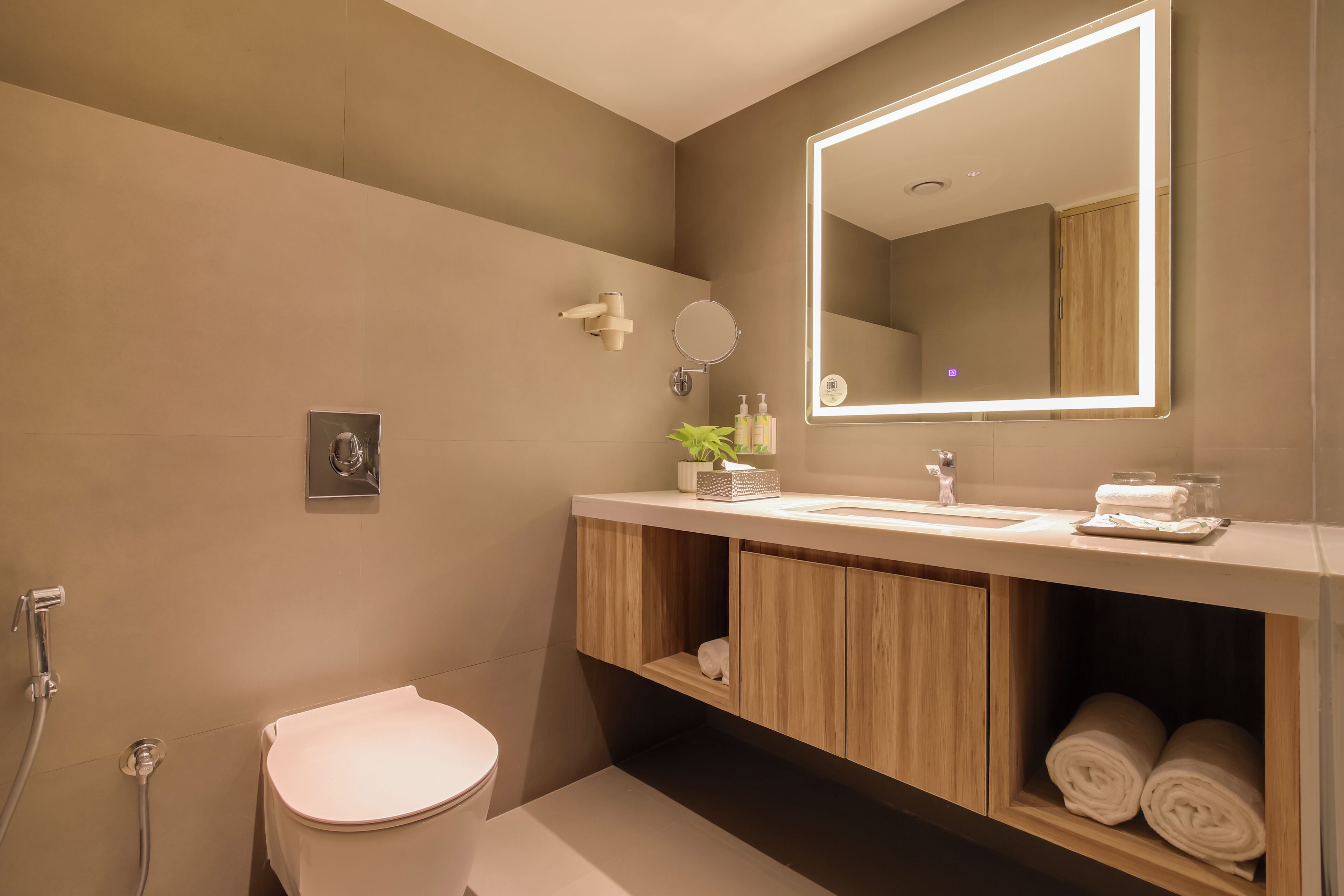 Een moderne badkamer met toilet, wastafel en spiegel.