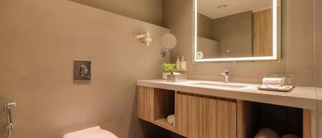 A modern bathroom with a toilet, sink, and mirror.