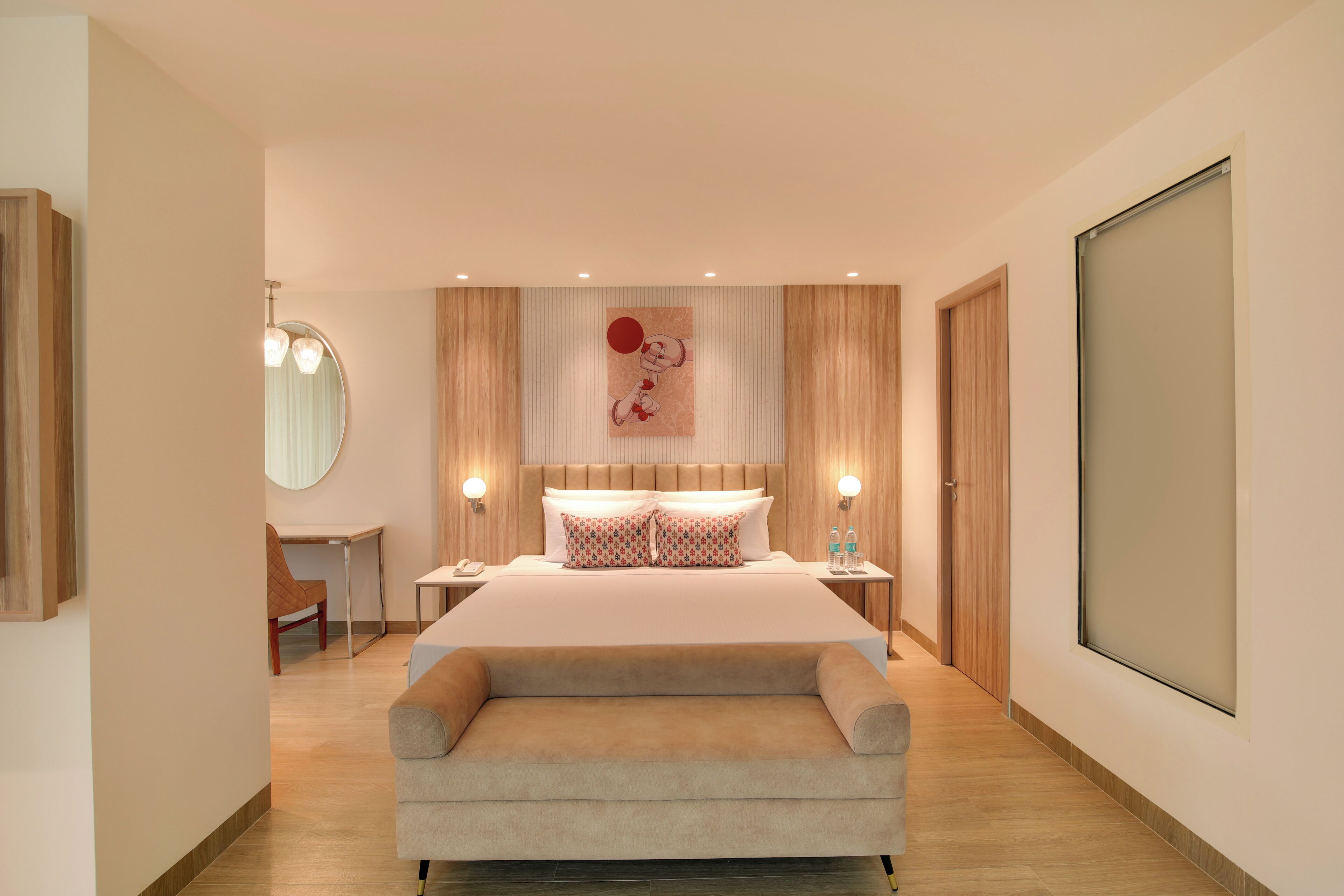 A modern bedroom with a large bed, bedside tables, a desk, and a sofa.