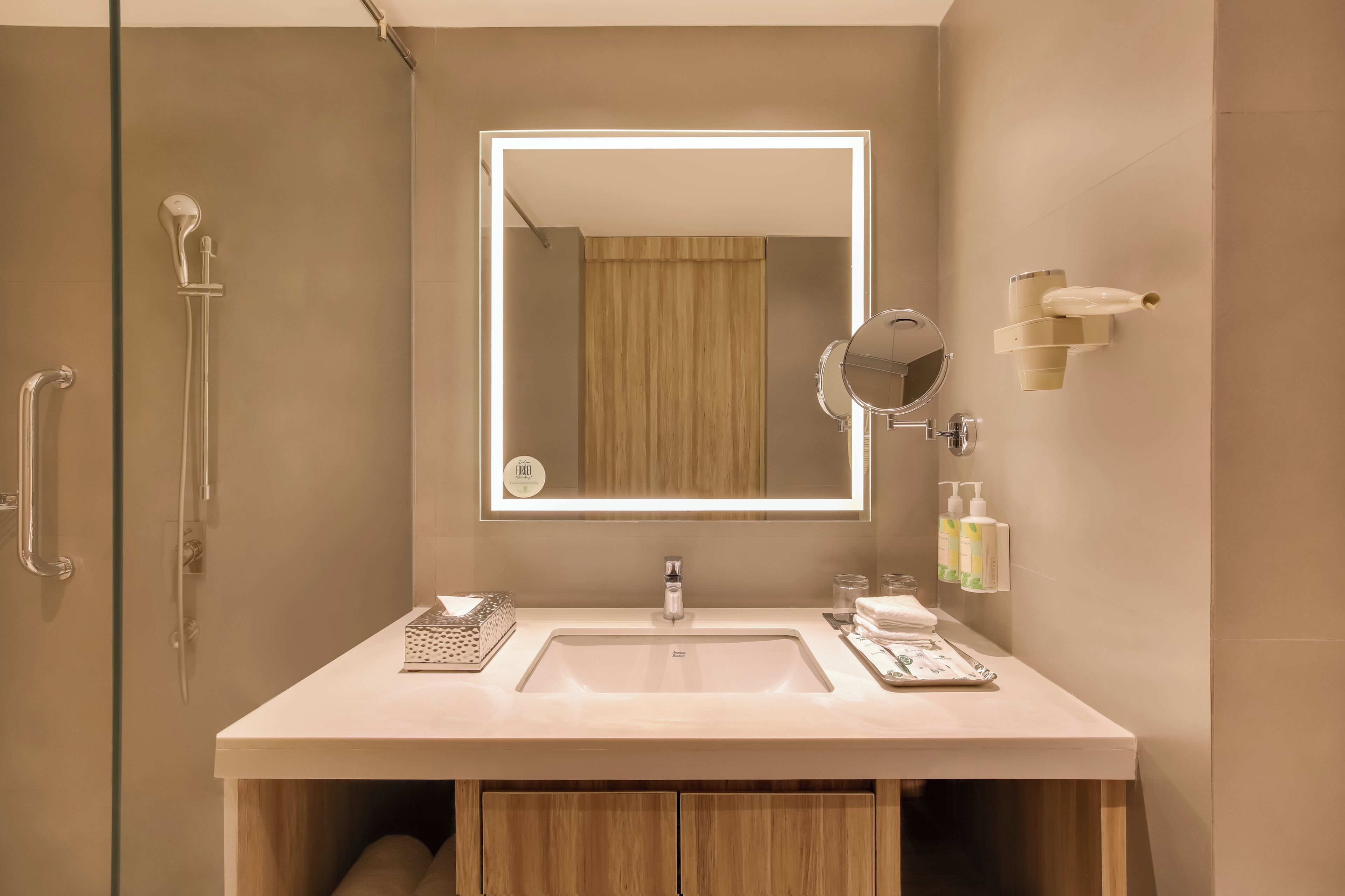 Une salle de bain moderne avec un grand miroir, un lavabo et une douche.