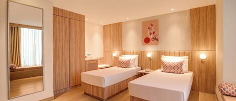 A hotel room with two beds, wooden paneling, a large mirror, and a wall-mounted artwork.