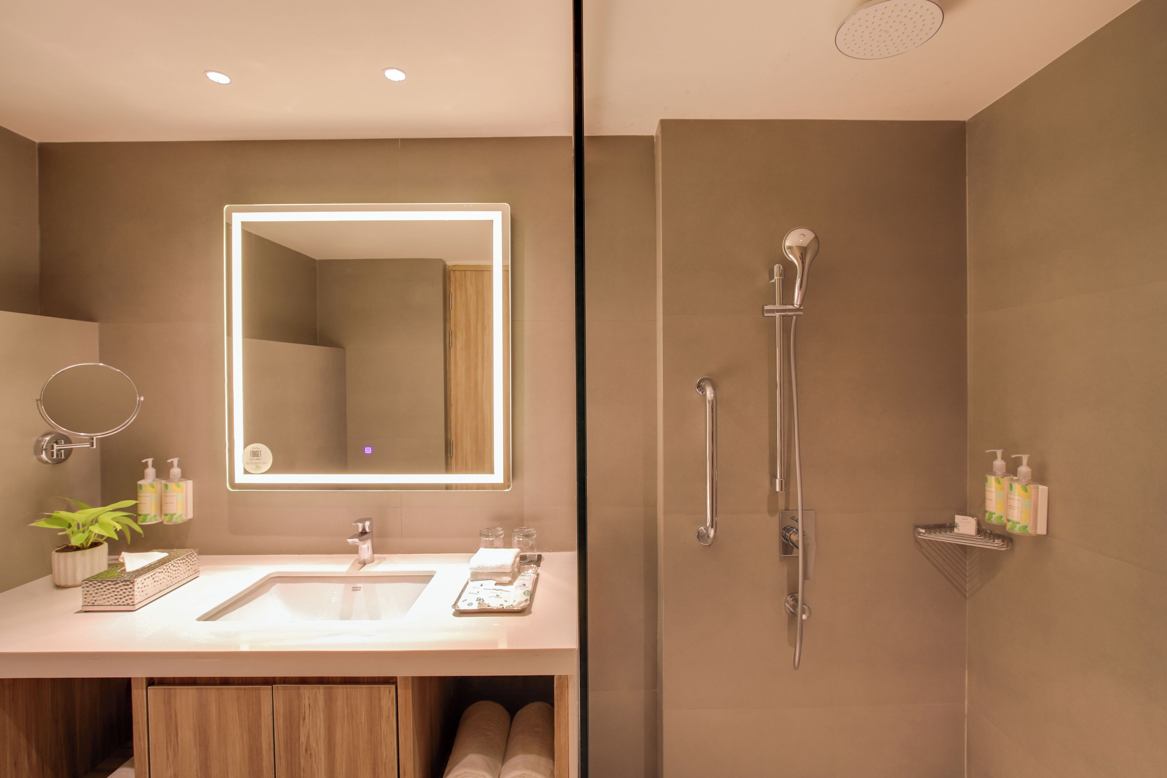 A modern bathroom with a large mirror, a sink, and a shower.