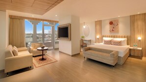 Et moderne hotelværelse med en stor seng, en sofa, et fjernsyn og et skrivebord.