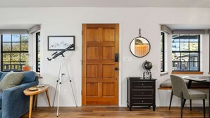 A living room with a wooden door, a telescope, a globe, and a framed picture on the wall. - Sagewood Cottage: A private home with comfort, style, amazing amenities, and Tranquil location! (Prescott)