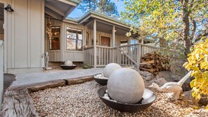 A house with a covered porch, a stone fireplace, and a gravel pathway. - Sagewood Cottage: A private home with comfort, style, amazing amenities, and Tranquil location! (Prescott)