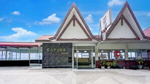 A hotel entrance with a traditional architectural style, featuring a prominent entrance and a sign that reads "GAPURA hotel".