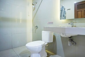 A bathroom with a toilet, sink, and shower. - OYO 94772 Gapura Hotel (Parapat)