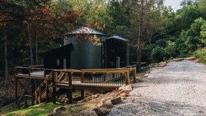 Eine Holzhütte mit einer Holzterrasse und einem Kiesweg, der dorthin führt.