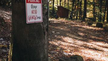 A sign on a tree indicating reserved parking for a specific group.