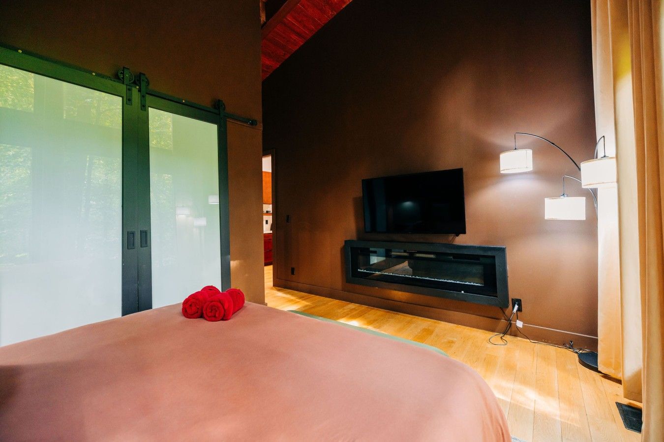 Une chambre à coucher avec un lit, une télévision et une cheminée.