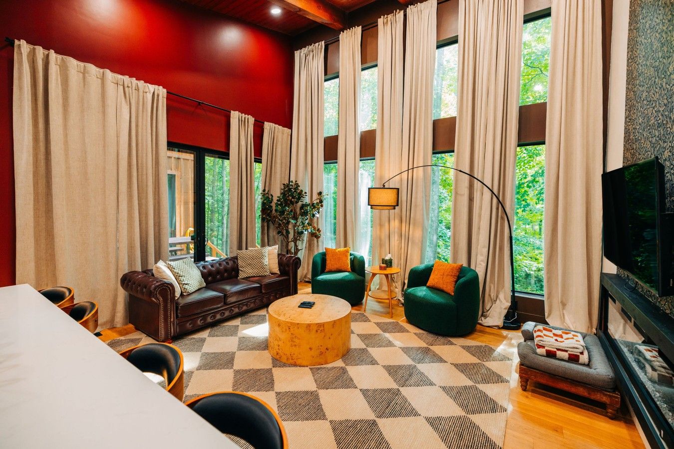 A living room with a sofa, armchairs, a coffee table, and a TV.