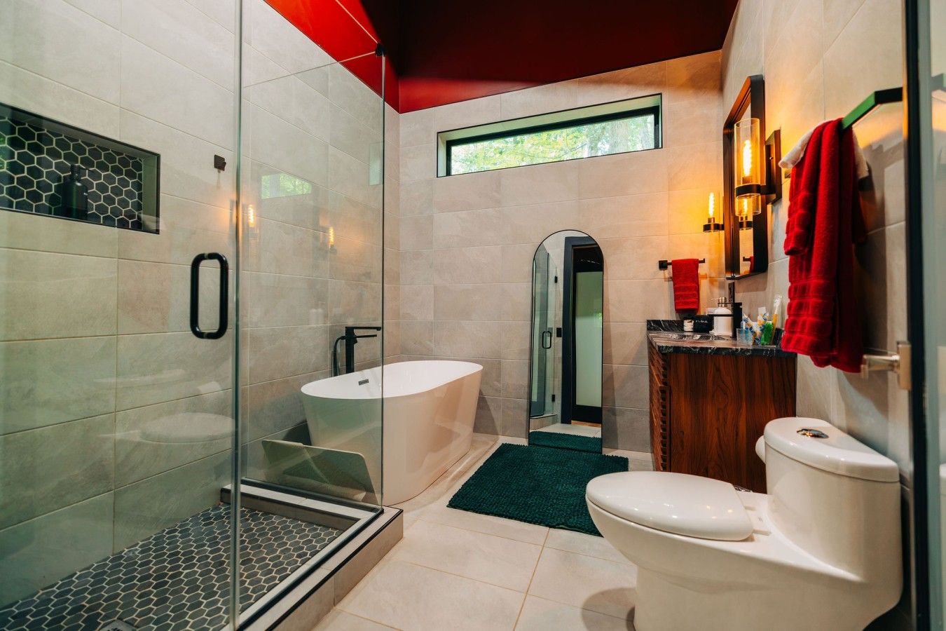 A modern bathroom with a glass-enclosed shower, a freestanding bathtub, and a separate toilet area.