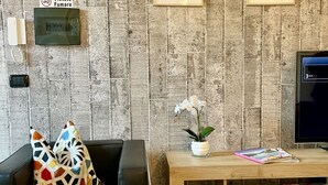 A wooden wall with a phone and a sign that reads "Vietato Fumare".