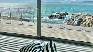 A balcony with a view of the ocean and rocky coastline. - Seafront Villa - Whale Bay Luxury Retreat (De Kelders)
