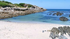 A beach with rocky terrain and clear blue water. - Seafront Villa - Whale Bay Luxury Retreat (De Kelders)