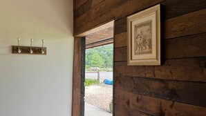A wooden wall with a framed picture and a light fixture. - The Riley Stable- Cozy Getaway (Waterlooville)