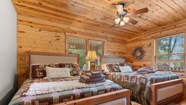 A cozy wooden cabin bedroom with two beds, a ceiling fan, and a window with a wreath. - ‼️Cozy 3BR Bloff Hytte w/ Mountain Views and BBQ (Sparta)
