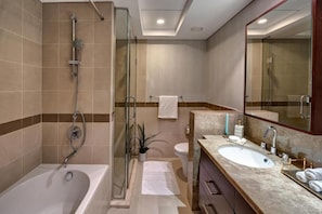 A modern bathroom with a bathtub, shower, and a vanity with a sink and mirror. - Durrani Homes - Designer 2BR Apt with stunning Burj Khalifa and Fountain View (Dubai)