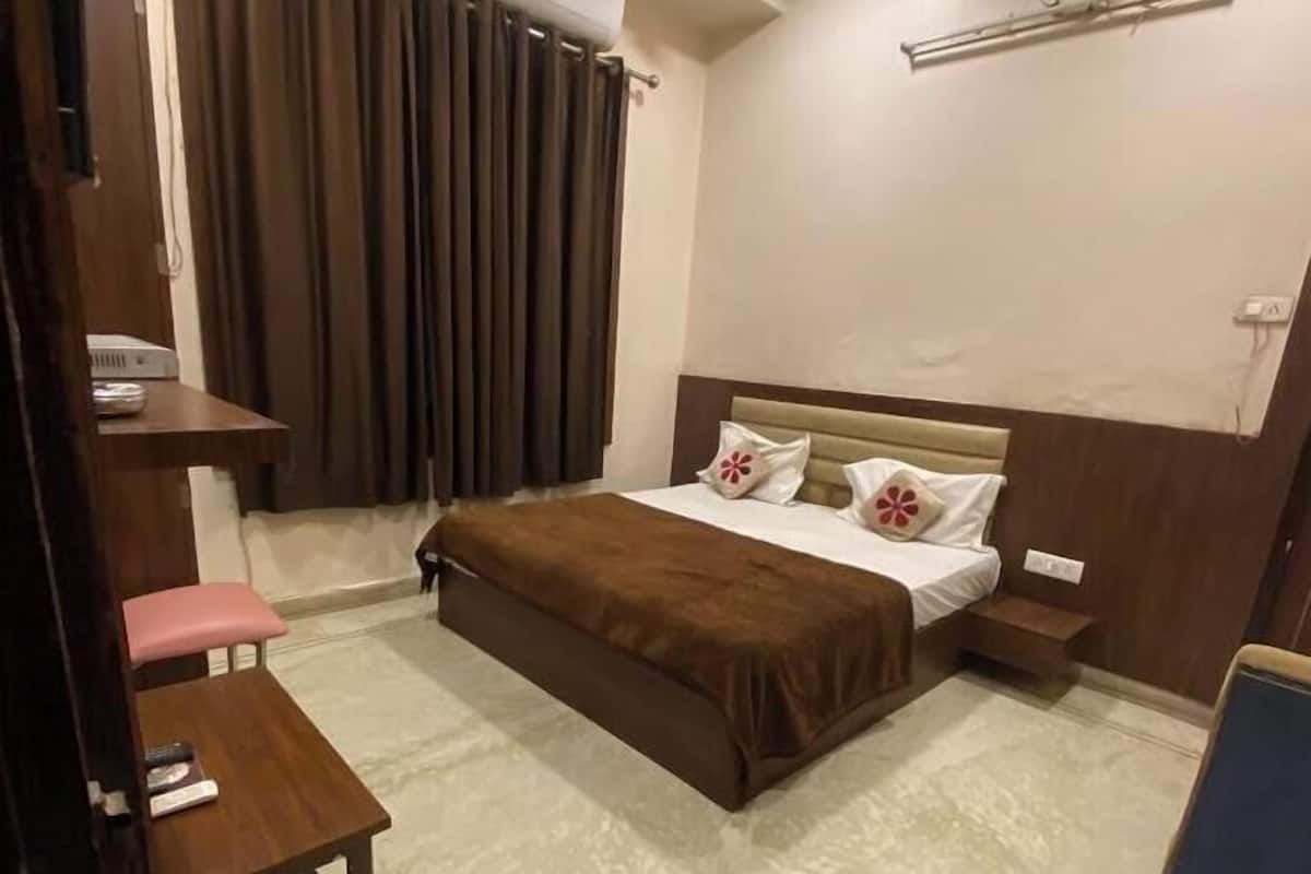 Une chambre à coucher avec un lit, une table de chevet et un bureau avec une chaise.