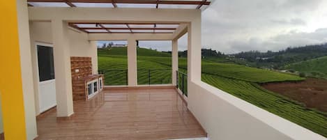 A balcony with a view of terraced fields.