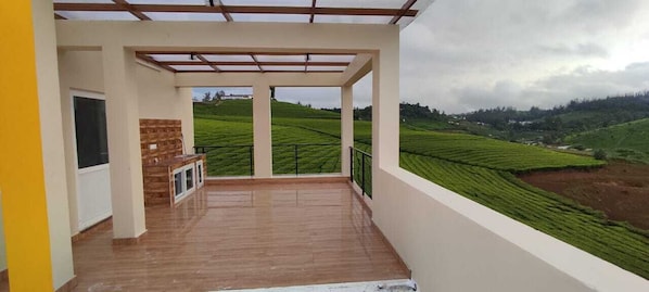 Un balcón con vistas a campos en terrazas.