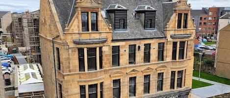 Ein historisches Gebäude mit Hauseingang, einem Geschäft im Erdgeschoss und einer Treppe zu den oberen Stockwerken.