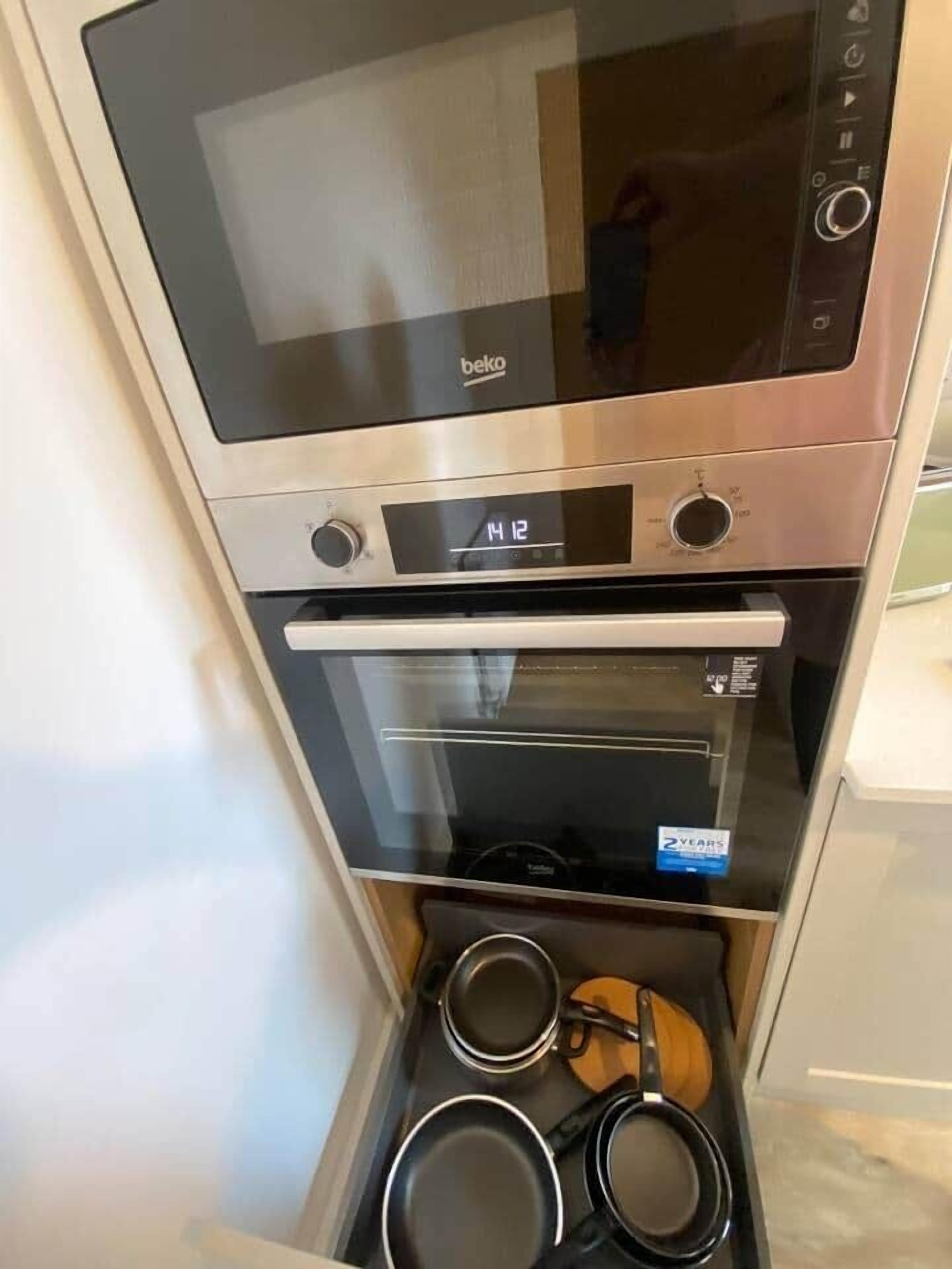 Eine Küche mit eingebautem Backofen und Mikrowelle.