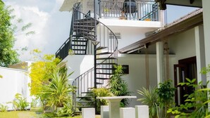 A two-story building with a spiral staircase leading to a balcony. - Ashlar Villa (Galle)
