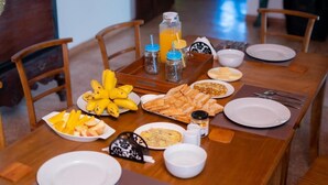 A dining table set with various breakfast items including fruits, bread, and condiments. - Ashlar Villa (Galle)