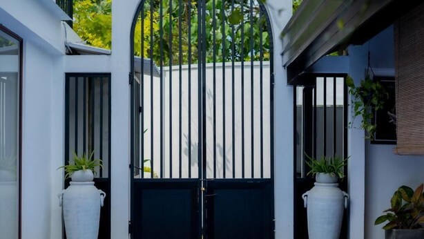 A gated entrance with a pool in the foreground. - Ashlar Villa (Galle)