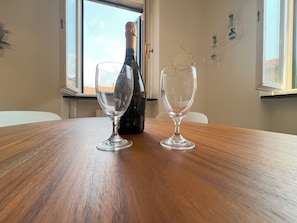 A wooden table with two wine glasses and a bottle of champagne. - GOLD APARTMENT (Rapallo)