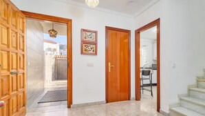 A hallway with a wooden door, a framed picture, and a staircase. - Holiday Home 'Casa Ramos Con Jacuzzi' with Sea View, Wi-Fi and Air Conditioning (Nerja)