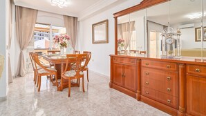 A dining area with a wooden table and chairs, a large mirror, and a clock on the wall. - Holiday Home 'Casa Ramos Con Jacuzzi' with Sea View, Wi-Fi and Air Conditioning (Nerja)