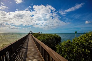 A wooden pier extending into calm waters, surrounded by lush greenery. - 1BR Condo w/ Ocean View, Pool & Private Beach (Tavernier)