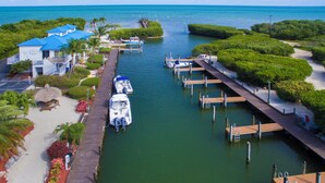 Un puerto deportivo con barcos amarrados, un muelle y un edificio con tejado azul.