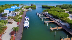 A marina with boats docked, a pier, and a building with a blue roof. - 1BR Condo w/ Partial Ocean View, Pool & Tennis (Tavernier)