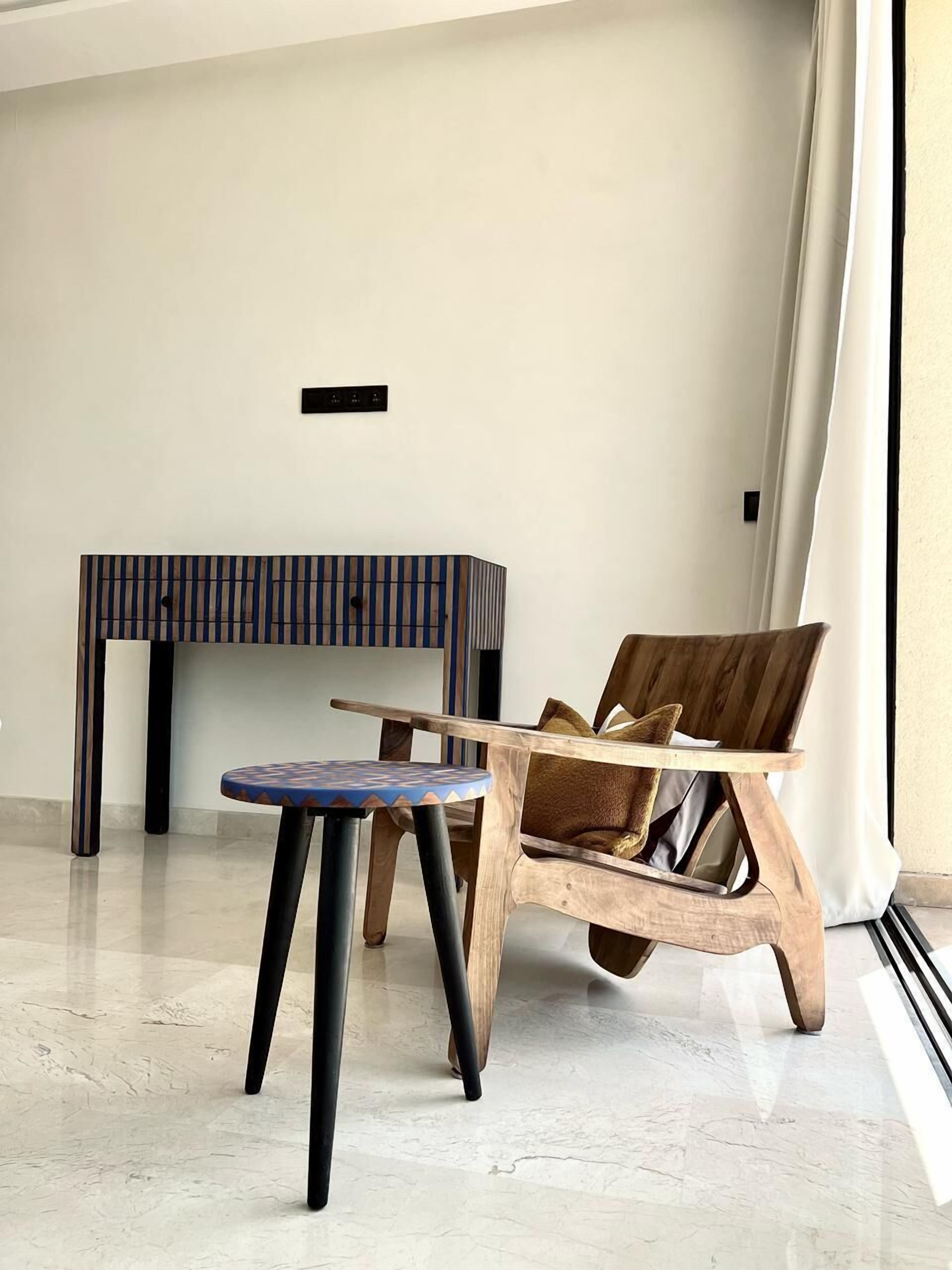 Un intérieur moderne avec une chaise en bois, une petite table et un banc.