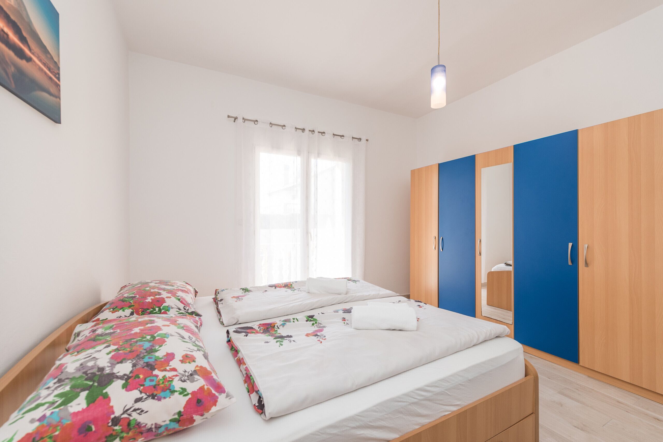 Un dormitorio con dos camas, un armario y una ventana con cortinas.