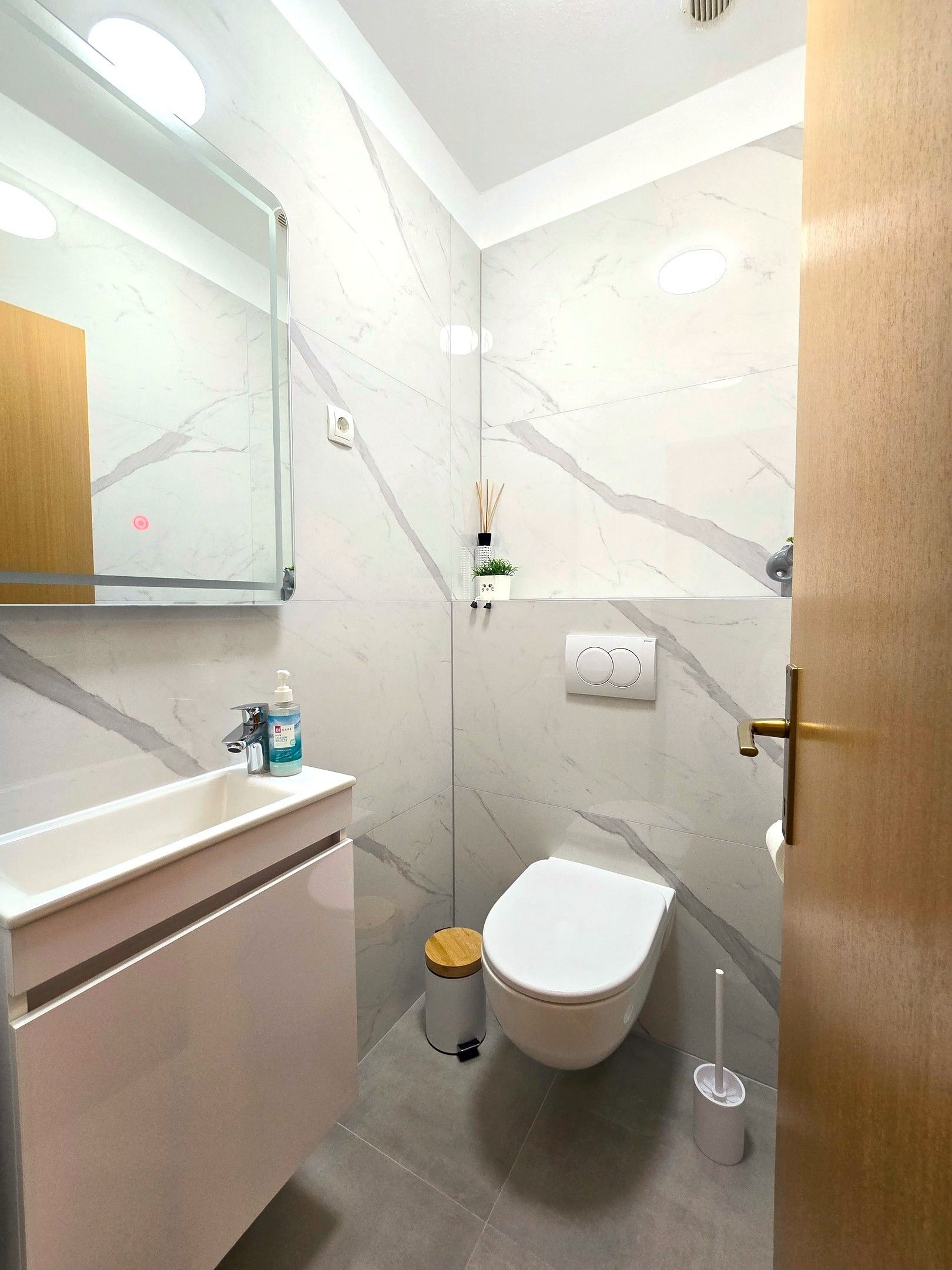 Ein modernes Badezimmer mit Toilette, Waschbecken und Spiegel.