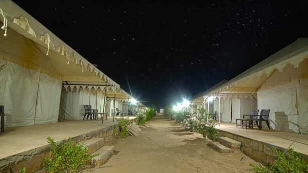A desert-style hotel with outdoor seating areas and tents. - Royal Gadhvi Desert Camp (Jaisalmer)