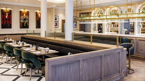 Un restaurant doté d’un long comptoir, de tables en alcôve et d’un bar.