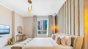 Een moderne hotelkamer met een groot bed, een televisie, een bureau en uitzicht op de stad.