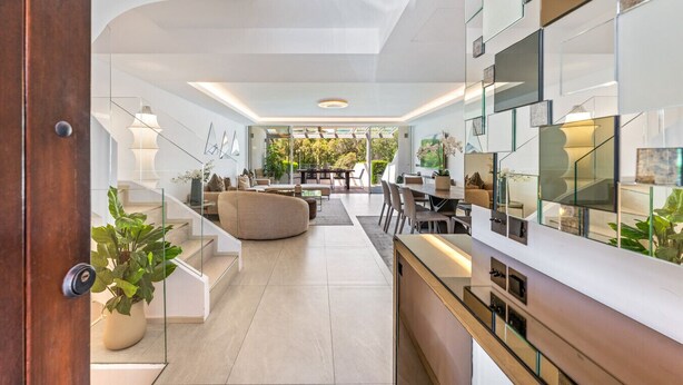Ein modernes Interieur mit Treppe, Essbereich und Wohnraum mit Aussicht.