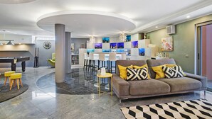 A modern living room with a sofa, a coffee table, and a bar area in the background. - Sunshine Villa in Vilamoura (Vilamoura)